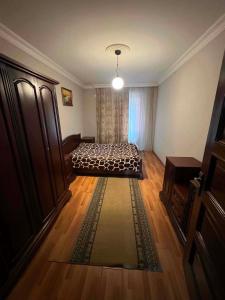 a bedroom with a bed and a rug on a wooden floor at there is no a name in Itʼkhvisi