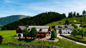 a large house on a green hill with trees at Kanzlei in Abtenau