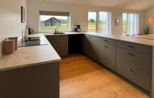 a large kitchen with white counters and a large island at 4 Bedroom Cozy Home In Haderslev in Haderslev