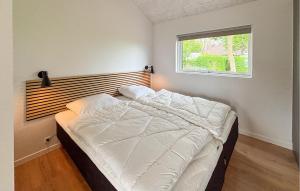 a bedroom with a white bed with a window at 4 Bedroom Cozy Home In Haderslev in Haderslev +13 photos