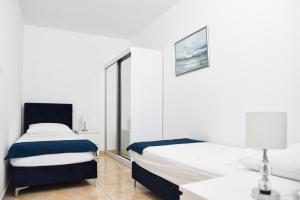 a bedroom with two beds and a table with a lamp at Hvar beach vacation in Vrboska