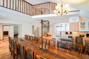 a dining room and kitchen with a large wooden table at Ehtookehto in Tahkovuori