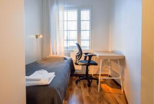 a small room with a desk and a bed and a chair at Ehtookehto in Tahkovuori