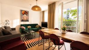 a living room with a table and a green couch at URBAN FLATS Berlin in Berlin
