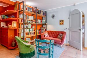 a living room with a couch and chairs and bookshelves at Le Clos Des Chênes in Lagarde-Paréol