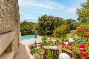 an outdoor patio with a swimming pool and flowers at Le Clos Des Chênes in Lagarde-Paréol
