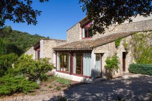 an old brick house with red windows and trees at Le Clos Des Chênes in Lagarde-Paréol