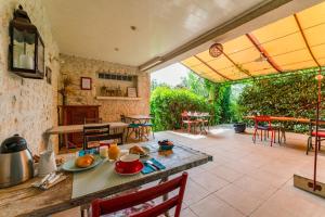 an outdoor patio with a table and chairs at Le Clos Des Chênes in Lagarde-Paréol
