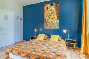 a blue bedroom with a bed and a painting on the wall at Le Clos Des Chênes in Lagarde-Paréol +70 photos