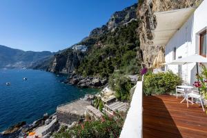 a house on the cliff with a view of the ocean at Le Suite dei Pescatori in Praiano