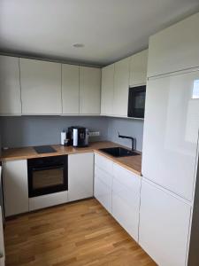 a kitchen with white cabinets and a sink at Külaliskorter Aardla tn 120 in Tartu +5 photos