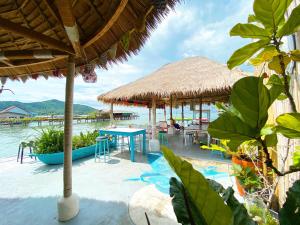 a resort with a table and chairs and water at The Boathouse in Bang Sare