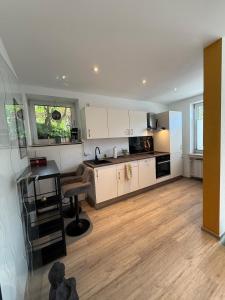a kitchen with white cabinets and a table and a desk at Nice and cozy in Daaden in Daaden