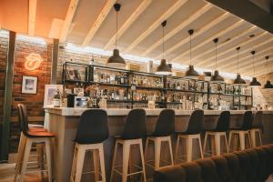 a bar with black chairs and a bar counter at GIARDINO High living suites in Drama