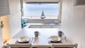 a kitchen with a table and a sailboat in a window at Superb Cintra Beachside Apartments in Llandudno