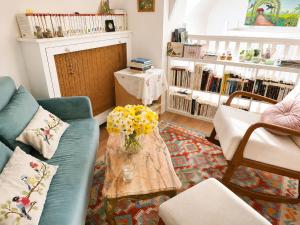 a living room with a couch and a table with flowers at Les oiseaux de passage - chambre d hôtes, paisible in Gaillon
