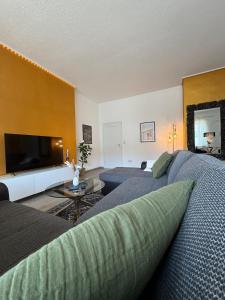 a living room with a couch and a flat screen tv at Nice and cozy in Daaden in Daaden