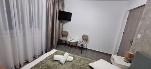 a hotel room with a bed and a table and chairs at Vila Armonia in Curtea de Argeş +25 photos