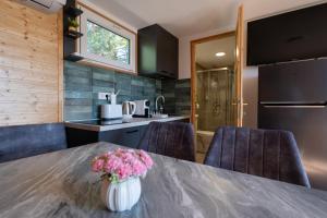 a kitchen and dining room with a table and chairs at Tisza-tavi Kiserdő Lodge in Tiszaderzs