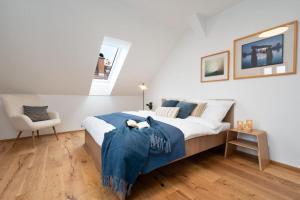 a bedroom with a bed with blue sheets and a chair at Apartmány Pod Jabloní in Jablonné nad Orlicí