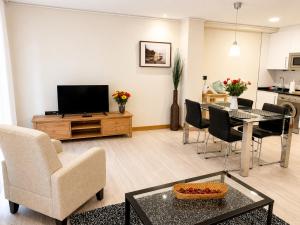 a living room with a television and a table and chairs at Les Cotolles Centro in Cangas de Onís