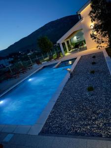 a swimming pool in front of a house at Kuća za odmor Nina in Čapljina