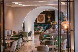 a dining room with tables and chairs and an archway at Droushia Heights Hotel in Drousha
