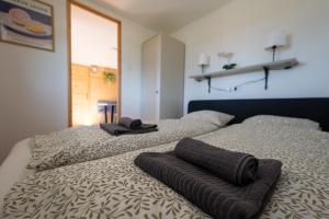 a bedroom with two beds with towels on them at Tisza-tavi Kiserdő Lodge in Tiszaderzs