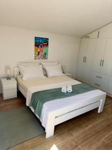 a bedroom with a large white bed with white cabinets at Kuća za odmor Nina in Čapljina