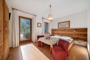 a bedroom with a table and chairs in a room at Mayrhof Zimmer, Bauernhofurlaub in San Pancrazio dʼUltimo