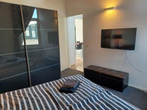 a bedroom with a bed with a tv on the wall at Bellevue Nr 123 - Lemmer in Lemmer