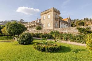a large brick building with a grassy yard in front at Romantic Historic Tower with Pool and Gardens in Baião