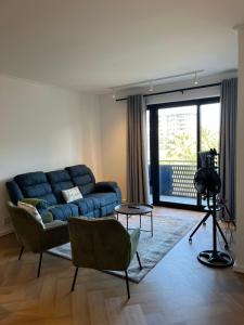 a living room with a blue couch and a window at Silhouette Suite at Nine Palms in Cape Town