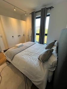a bedroom with a large white bed with a window at Silhouette Suite at Nine Palms in Cape Town