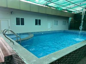 a large swimming pool with a water fountain at Aerodon resort in Chennai +8 photos