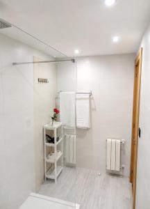 a white bathroom with a flower on a shelf at Les Cotolles Centro in Cangas de Onís +15 photos