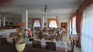 a large dining room with tables and chairs and flowers at Hotel Svizzero in Sangineto