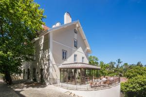 a large white building with a restaurant in front of it at Passeio Sintra Collection in Sintra