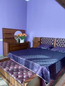a bedroom with a bed with purple sheets and a mirror at Hotel Odabade in Zugdidi