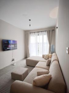 a living room with a couch and a large window at Chic One Bedroom Apartment near The Kenya School of Government - KSG in Nairobi