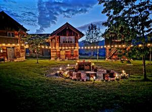 a log home with a fire pit in the yard at night at Sonnleiten Zimmer 4 in Abtenau