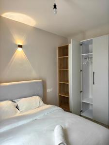 a bedroom with a white bed and a closet at Chic One Bedroom Apartment near The Kenya School of Government - KSG in Nairobi +43 photos