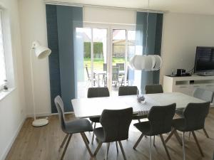 a dining room with a white table and chairs at Pier 76 in Scharbeutz