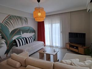 a living room with a couch and a tv at Likehome Apartments in Orestiada