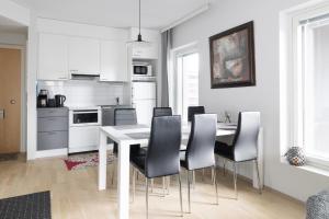 a kitchen with a dining room table and chairs at Moderni avara yksiö Jyväskylän ydinkeskustassa in Jyväskylä +16 photos