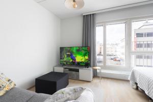 a living room with a flat screen tv on a table at Moderni avara yksiö Jyväskylän ydinkeskustassa in Jyväskylä