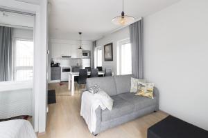 a living room with a couch and a dining room at Moderni avara yksiö Jyväskylän ydinkeskustassa in Jyväskylä
