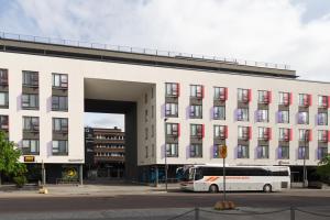 a bus is parked in front of a building at Moderni avara yksiö Jyväskylän ydinkeskustassa in Jyväskylä