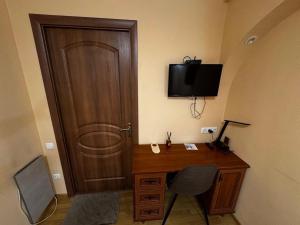 a room with a desk and a door with a television at Old Town - Andrew descent in Kyiv
