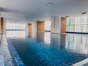 a large swimming pool with blue water in a building at Le Conde Maison in Phnom Penh